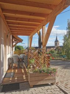 a wooden deck with two chairs and a table at Gîtes Marschall Jean-Pierre in Beblenheim