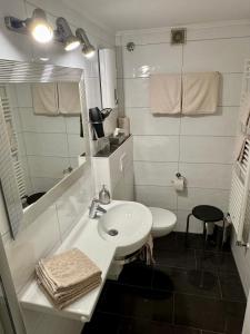 a white bathroom with a sink and a mirror at Haus Edeltrud - Ferienwohnung Moselufer in Bernkastel-Kues