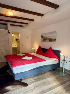 a bedroom with a large bed with red pillows at Haus Edeltrud - Ferienwohnung Moselufer in Bernkastel-Kues