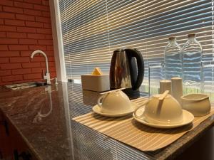 a kitchen counter with plates and a tea kettle on it at Sol & Luna in Katunayaka +57 photos
