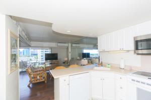 a kitchen with white cabinets and a table and chairs at Ilikai Tower 633 in Honolulu