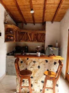 a kitchen with a counter with two chairs and a table at Cabaña campestre in Medellín