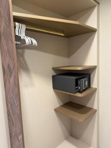 a walk in closet with a microwave on shelves at Baires Guest House 2 in Milan