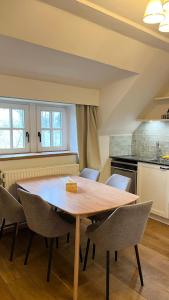 a kitchen with a wooden table and chairs at B&B La Ferme de l'Hosté in Wavre