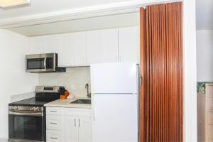 a kitchen with white cabinets and a white refrigerator at Ilikai Marina 1285 in Honolulu