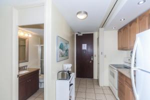 a kitchen with a refrigerator and a sink at Ilikai Marina 1381 in Honolulu
