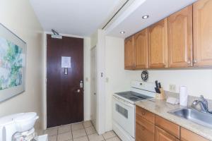 a kitchen with wooden cabinets and a sink at Ilikai Marina 1381 in Honolulu