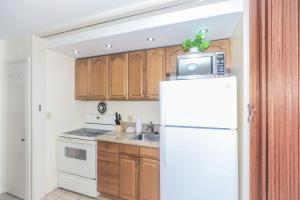 a kitchen with a white refrigerator and a microwave at Ilikai Marina 1381 in Honolulu +15 photos