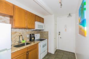 a kitchen with a sink and a stove top oven at Ilikai Marina 1383 in Honolulu