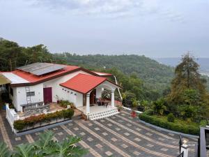 a house with a red roof and a patio at Nethra Darshan in Mangalore