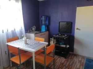 a small kitchen with a table and a television at Apartamento Cuadruple in Isla de Maipo