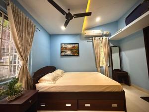 a bedroom with a bed and a ceiling fan at Nethra Darshan in Mangalore
