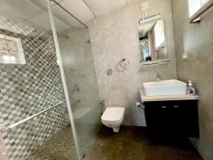 a bathroom with a shower and a toilet and a sink at Nethra Darshan in Mangalore +26 photos