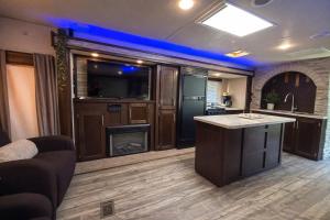 a living room with a bar with a tv and a kitchen at Rincon Camper Retreat in Rincon