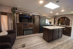 a living room with a kitchen with a tv and a kitchen at Rincon Camper Retreat in Rincon