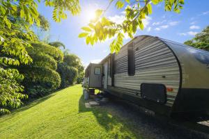 a metal trailer parked in a grass field at Rincon Camper Retreat in Rincon