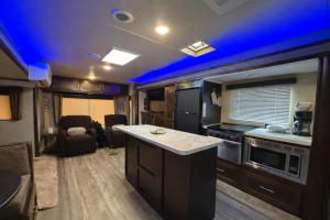 an rv kitchen with blue lights on the ceiling at Rincon Camper Retreat in Rincon +2 photos