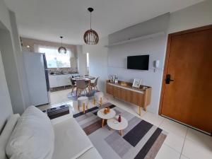 a living room with a white couch and a table at Calma e tranquilidade em Barra Velha in Barra Velha