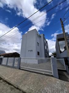 a white building with a fence in front of it at Calma e tranquilidade em Barra Velha in Barra Velha