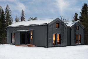 a black house in the snow with trees at Vuokatti Weekend Platinum in Vuokatti