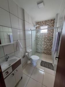 a white bathroom with a toilet and a shower at Calma e tranquilidade em Barra Velha in Barra Velha +16 photos