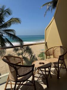 a balcony with chairs and a table and a view of the beach at Piña Boutique Hotel - Beachfront in Habaraduwa Central