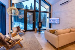 a living room with a couch and a large window at Vuokatti Weekend Platinum in Vuokatti