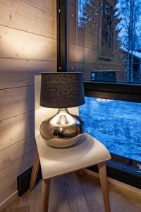 a lamp sitting on a chair next to a window at Vuokatti Weekend Platinum in Vuokatti
