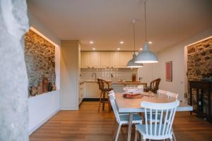 a kitchen and dining room with a table and chairs at Just Like Home - Casa do Botijal in Caminha