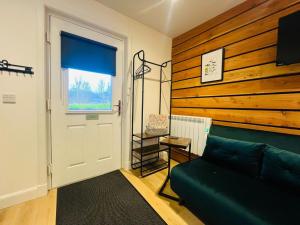 a living room with a green couch and a window at The Canal Cabin in Banavie