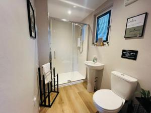 a bathroom with a shower and a toilet and a sink at The Canal Cabin in Banavie +11 photos
