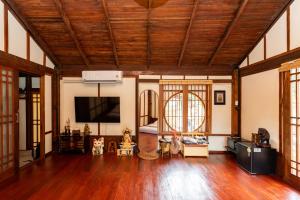a living room with wooden ceilings and a flat screen tv at Aki house in Ban Bung Toei