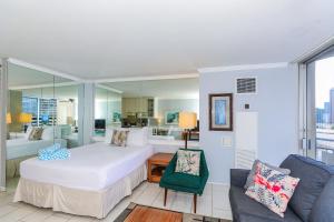 a bedroom with a large white bed and a couch at Ilikai Marina 987 in Honolulu