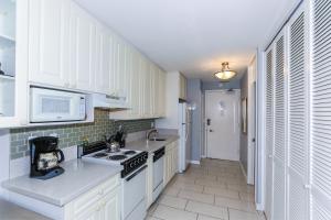 a kitchen with white cabinets and a stove at Ilikai Marina 987 in Honolulu