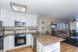 a kitchen with white cabinets and a counter top at Ilikai Marina 984 in Honolulu