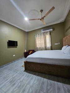 a bedroom with a bed and a ceiling fan at Gifted Estates in Accra