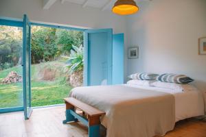 a bedroom with a bed and a large window at Just Like Home - Casa do Botijal in Caminha