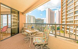 a balcony with a table and chairs and a view of the city at Discovery Bay 1419 in Honolulu