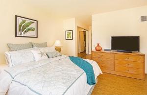 a bedroom with a bed and a television on a dresser at Discovery Bay 1419 in Honolulu
