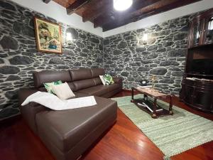a living room with a leather couch and a table at Casa Gouveia in Ribeira Brava