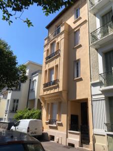 a building with balconies and cars parked in front of it at Les Sources Vichy in Vichy