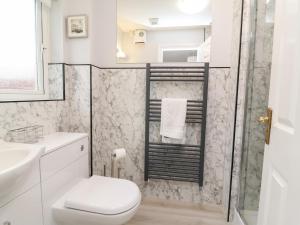 a white bathroom with a toilet and a sink at Fairways in Woolacombe +23 photos