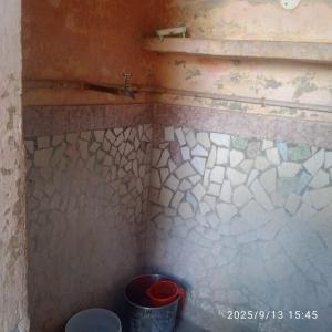 a corner of a bathroom with a trash can at Balaji Shridham in Jāmb