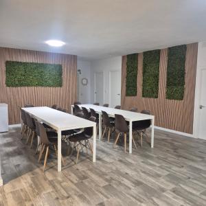 a conference room with white tables and chairs and plants on the wall at Casa Rural Mayné in Villafranca de los Caballeros +42 photos