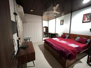 a bedroom with a large bed with a red blanket at Amor Villa Abu in Mount Ābu