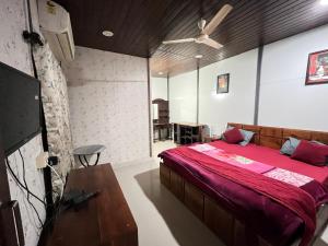 a bedroom with a large bed with a red blanket at Amor Villa Abu in Mount Ābu +9 photos