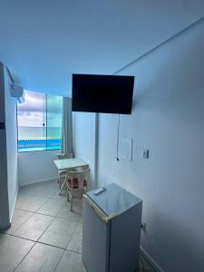 a room with a refrigerator and a table and a window at Vista Beach Ingleses in Florianópolis