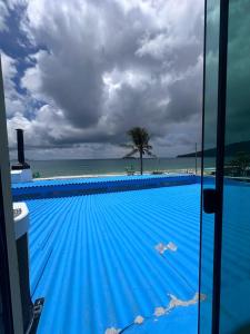 a blue swimming pool with the ocean in the background at Vista Beach Ingleses in Florianópolis