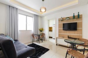 una sala de estar con un sofá y una mesa en Apartamento Floripa, en Florianópolis