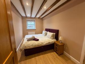 a small bedroom with a bed and a window at The Granary, Wolds Way Holiday Cottages, spacious 3 bed cottage in Cottingham